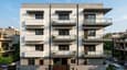 3D elevation render of the 40x60 north facing 4-floor home — contemporary facade with alternating solid and glazed bays, stone cladding base, white upper floors, staggered balcony projections