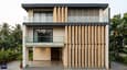Design highlight — contemporary north-facing 60x60 G+2 elevation with vertical stone fins, frameless glass balcony, and double-height entrance