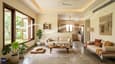 Interior view of 25x30 south-facing home showing north-facing living room with bright natural light, large windows, cross-ventilation arrows, overhang shadow visible on south wall, minimal furniture emphasizing natural light and airflow, modern Indian interior design