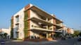 Hero image of a four-story south-facing townhouse with deep overhangs and vertical green spaces