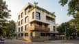 Modern four-floor north-facing contemporary Indian home on a 30x40 plot with staggered balconies, stone-clad base, and dark aluminium windows
