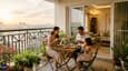 Lifestyle image of a family enjoying morning tea on the east-facing balcony of a 40x60 four-floor house with sunrise light flooding the living area behind them
