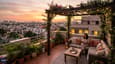 Lifestyle image of a west-facing terrace on a G+3 urban compound at golden hour with city views in the background