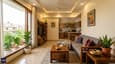 Modern Indian living room with north-facing window, soft light, grey sofa, and open kitchen