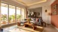 Modern south-facing living room flooded with natural light, grey sofa, Indian accents, open to bright kitchen