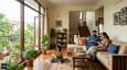 Family using the bright north-facing family lounge in their G+1 home — natural light, cross-ventilation