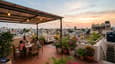 Rooftop terrace lifestyle on a south-facing G+3 home with outdoor seating, solar canopy, potted garden, and open city views
