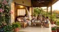 Indian family relaxing on west-facing veranda at golden hour with warm evening light and breeze
