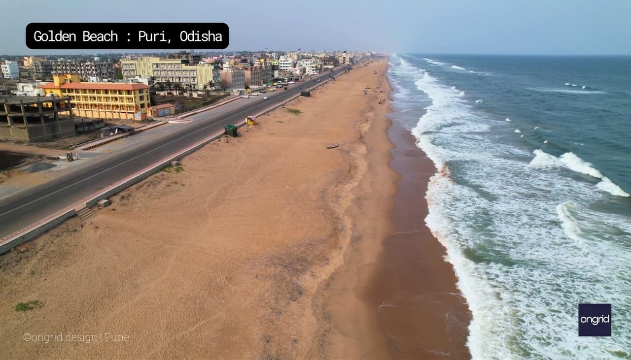 The image shows the beach house site before construction began. The site is located on a sandy beach, and it is surrounded by palm trees. There is a small building on the site that was used as a construction office during the construction of the beach house.